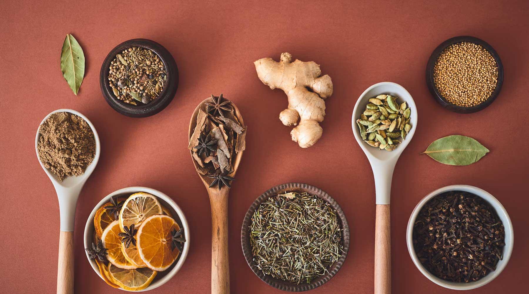 Variedad de adaptógenos, especias y jengibre sobre fondo marrón, bienestar Sensus.life